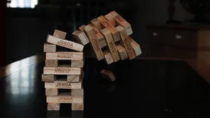 A tower of Jenga blocks captured mid-way through the top of the tower falling over.